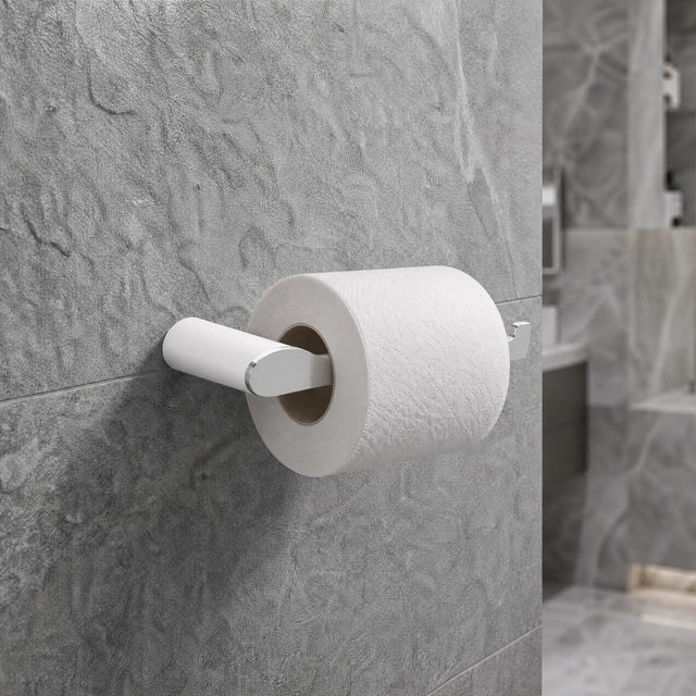 Roll of toilet paper on a holder against a tiled bathroom wall.