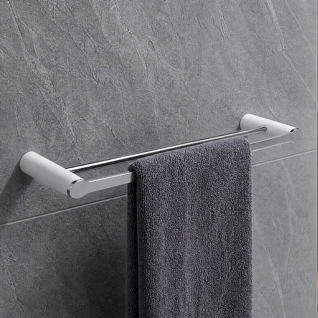 Gray towel hanging on a towel rack in a modern bathroom with gray tiles.