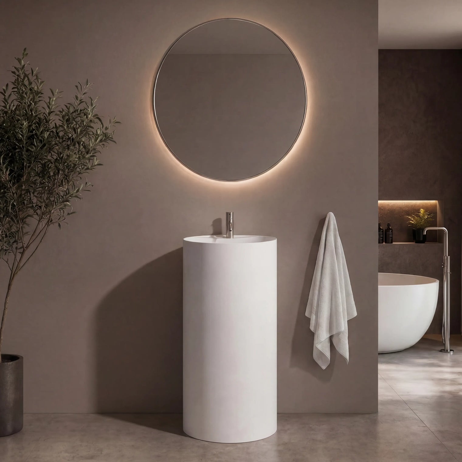 Modern bathroom with a round mirror, pedestal sink, and plant.