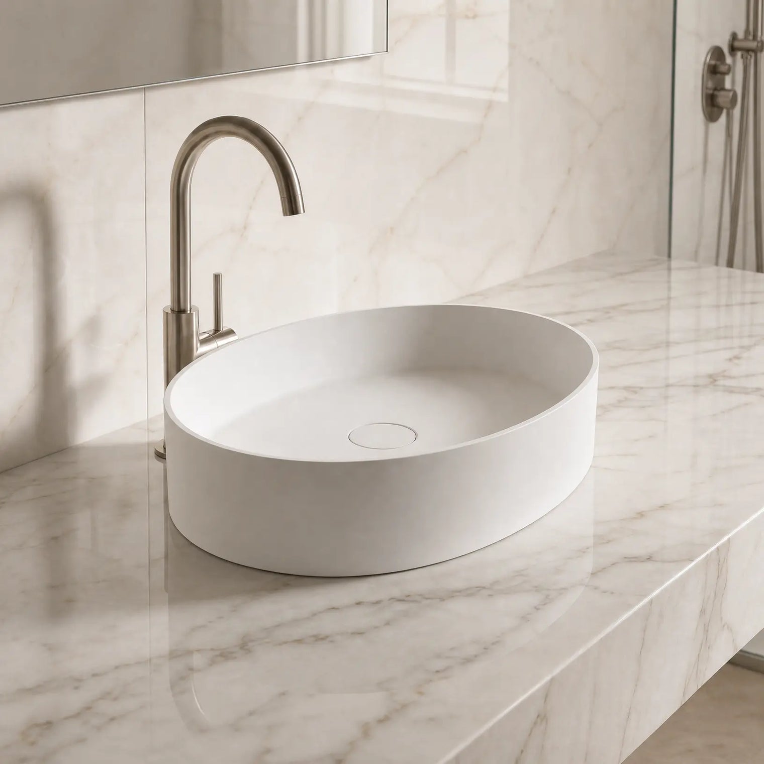 White Solid Surfaces oval sink on a marble countertop with a silver faucet.