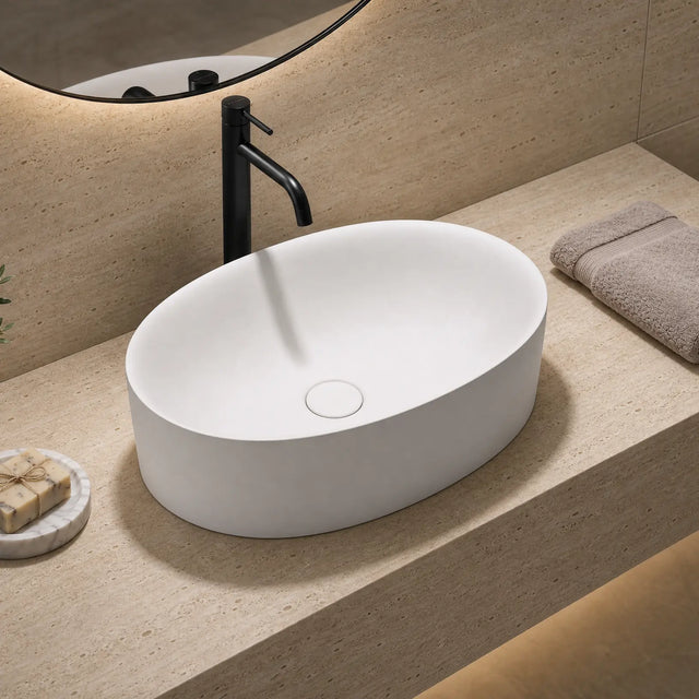 Bathroom sink with black faucet, towel, and soap on a beige countertop.