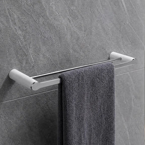 Gray towel hanging on a towel rack in a modern bathroom with gray tiles.