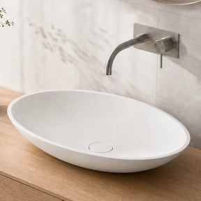 Bathroom vanity with a white sink, wooden cabinet, and decorative elements.