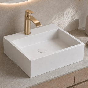 White rectangular sink with gold faucet on a beige countertop