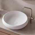 Bathroom vanity with a white sink, wooden cabinet, and decorative elements.