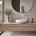 Bathroom vanity with a round sink, faucet, and decorative elements.