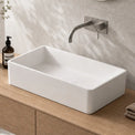 Bathroom vanity with white sink, wooden cabinet, and decorative elements.