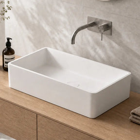 Bathroom vanity with white sink, wooden cabinet, and decorative elements.