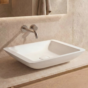 Bathroom vanity with a white sink and wooden cabinet.