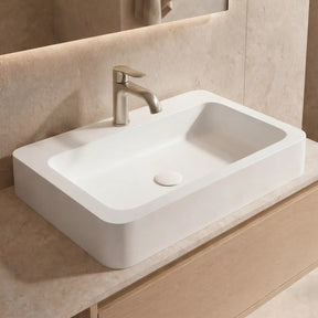 Bathroom vanity with a white sink and wooden cabinet, featuring a neutral color scheme.