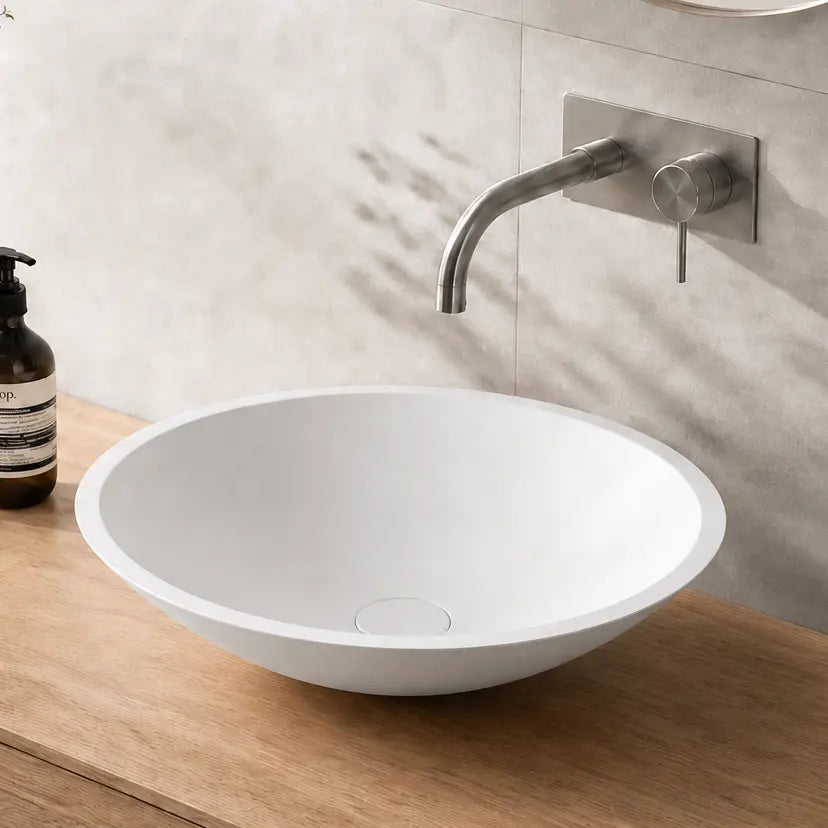 Bathroom vanity with wooden countertop, white sink, and decorative items.