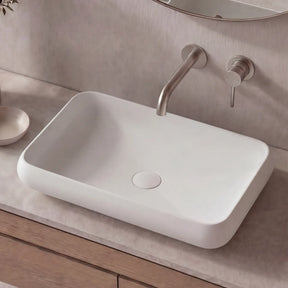 Bathroom vanity with a white sink, wooden cabinet, and decorative elements.