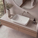 Bathroom vanity with a white sink, wooden cabinet, and decorative elements.
