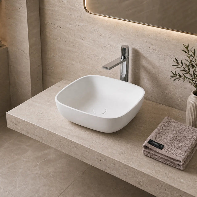 Bathroom vanity with white solid surfaces sink, faucet, and decorative elements.