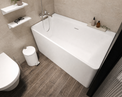 A modern freestanding white bathtub in a minimalist bathroom setting with beige textured walls, dark wood-look flooring, floating white shelves, and a white toilet visible in the corner.