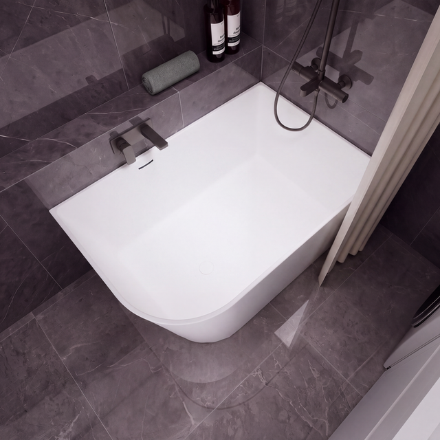 A modern white freestanding bathtub with a dark gray tiled bathroom setting, featuring a wall-mounted chrome faucet, a handheld shower attachment, and a beige curtain on the left.