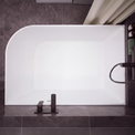 A modern freestanding rectangular bathtub with rounded corners, shown installed against dark gray tiled walls and floor. The tub is matte white, with matte black fixtures mounted on the right side and a matching black faucet centered at the bottom.