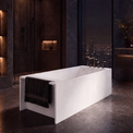 A modern freestanding rectangular bathtub in matte white, shown in a luxurious dark-toned bathroom with a city skyline visible through large windows at night.