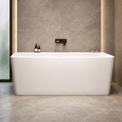 A modern bathroom interior featuring a freestanding white bathtub centered against a textured gray stone wall with warm LED lighting, alongside a floating white sink, mirror, toilet, and open shelving.