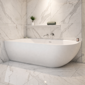 A modern freestanding bathtub in a bright marble-look bathroom with a glass shower enclosure, matching tiled walls and floor, recessed lighting, and built-in shelves.