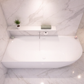 A modern white freestanding bathtub set into a light marble bathroom with a matching marble surround, a small shelf with a plant and soap, and a chrome faucet.