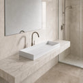Modern bathroom with a white sink on a marble countertop, large mirror, and shower area.
