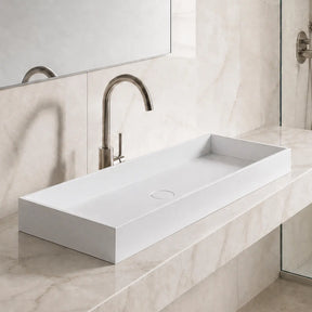 Modern bathroom with a white sink on a marble countertop, large mirror, and shower area.