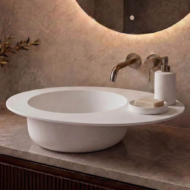 Modern bathroom vanity with a white sink, illuminated mirror, and decorative elements.