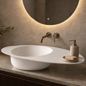 Modern bathroom sink with illuminated mirror and decorative elements.