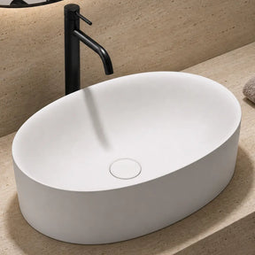 Bathroom sink with black faucet, towel, and soap on a beige countertop.