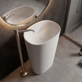 Modern freestanding sink in a bathroom setting with a mirror and tiled floor.