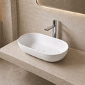Modern bathroom with a white Solid Surfaces sink on a beige countertop