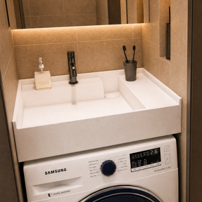 A Samsung front-load washing machine in a modern bathroom setting next to a walk-in shower stall with beige tiled walls.