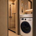 A modern bathroom interior featuring a white Samsung front-load washing machine with a dark navy blue drum, positioned next to a glass-enclosed shower stall with warm beige tiled walls.