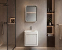 Modern bathroom with a white sink and mirror against a beige wall.